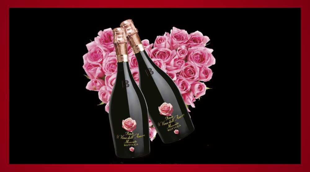 Bouteille de cprosecco sur une bouquet de fleurs en cœur