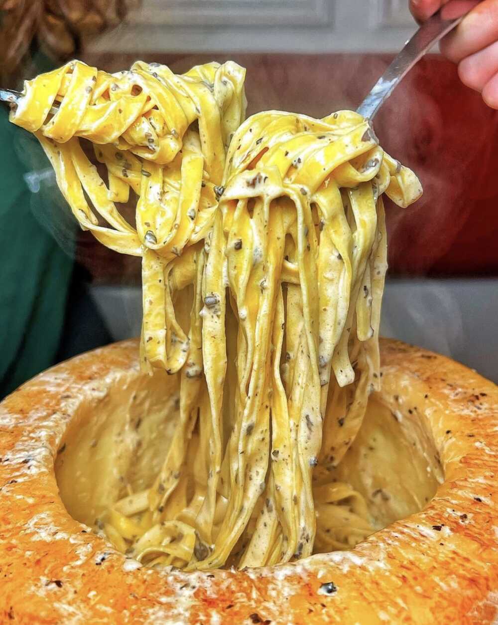Gruppomimo pâtes mélangées dans une meule de parmesan